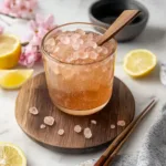 A glass of iced Japanese pink salt tonic with lemon and honey on a white marble table